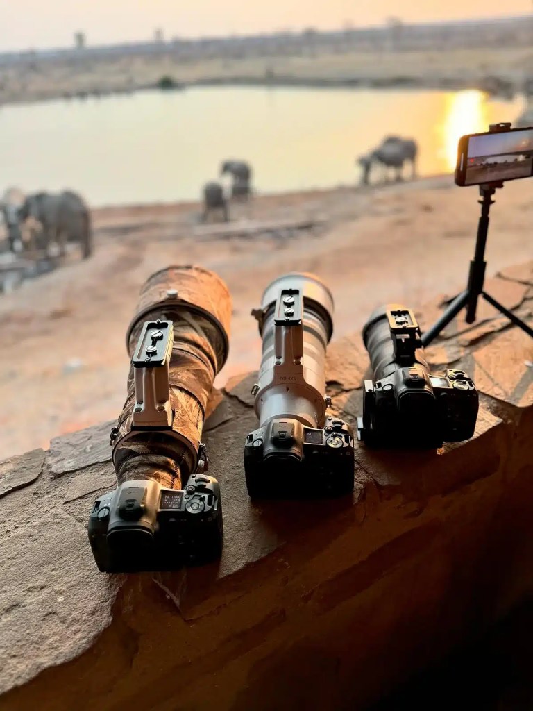 Canon RF 400mm f2.8 lenses used for African photo safari, with elephants in the background at a waterhole.