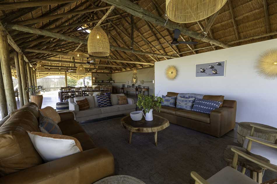 Camp Hwange lounge area with thatched roof, leather sofas, and African safari decor. A great place for a photo safari!