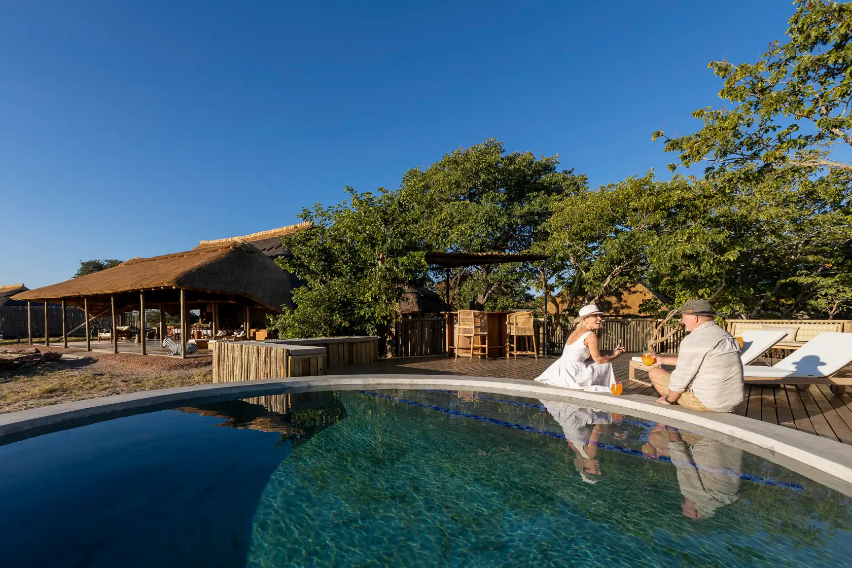 Camp Hwange: Couple relaxing by the pool on an African photo safari.