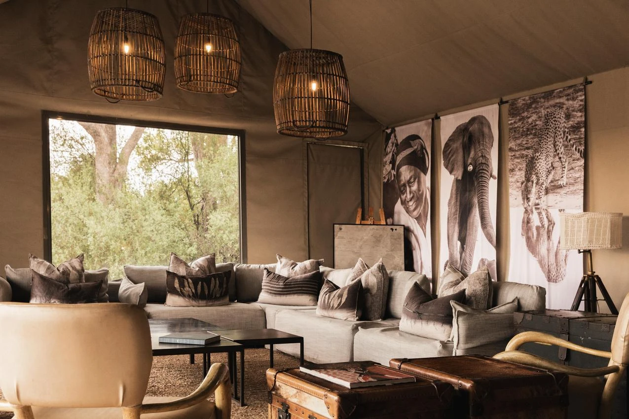 Luxury safari tent interior with African art, wicker lamps, and comfortable seating for a memorable photo safari.