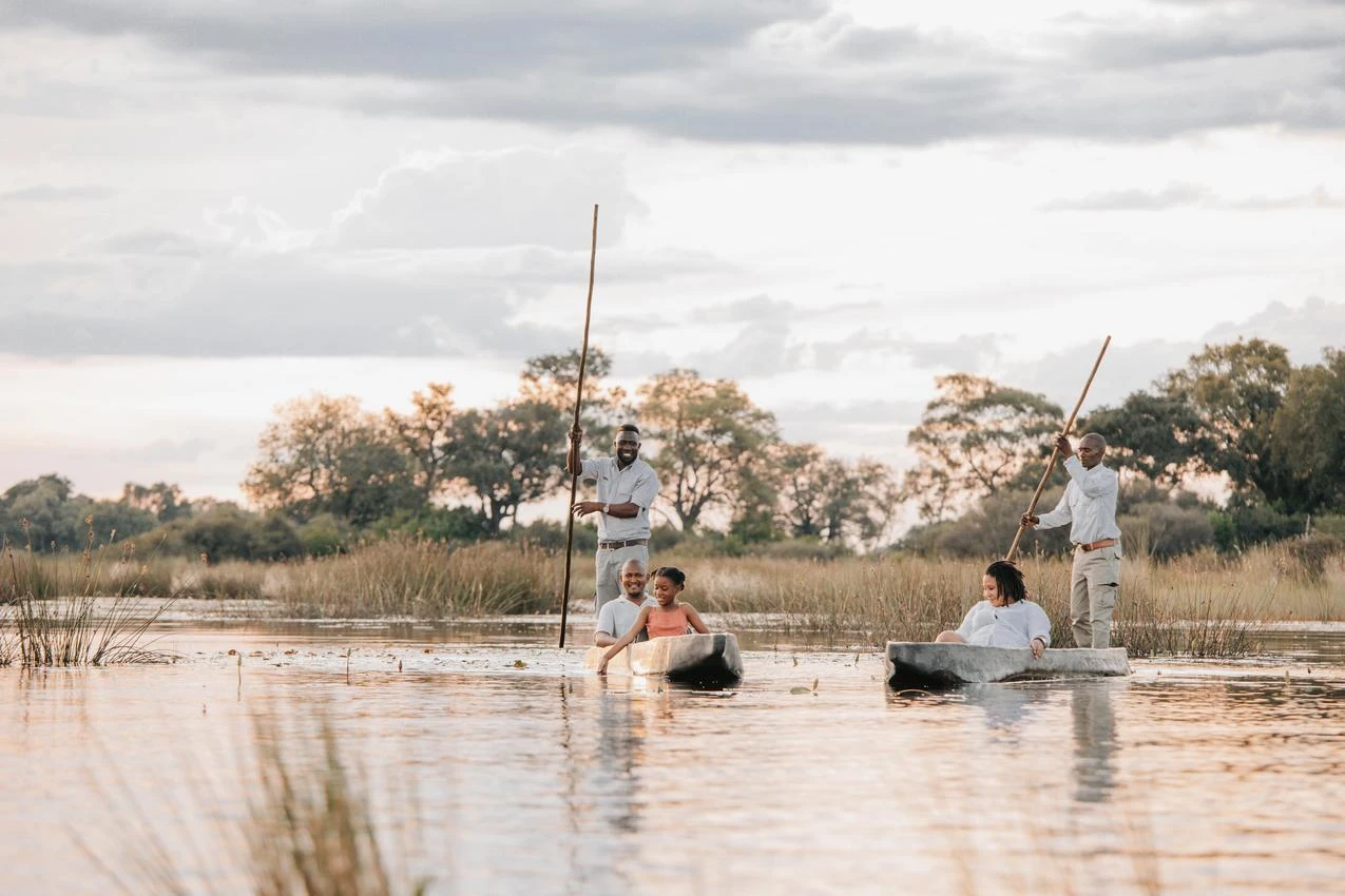 Okavango Delta photo safari in Botswana: Family on a mokoro canoe trip in Okavango Delta, Botswana. Photo safari adventure through wetlands.