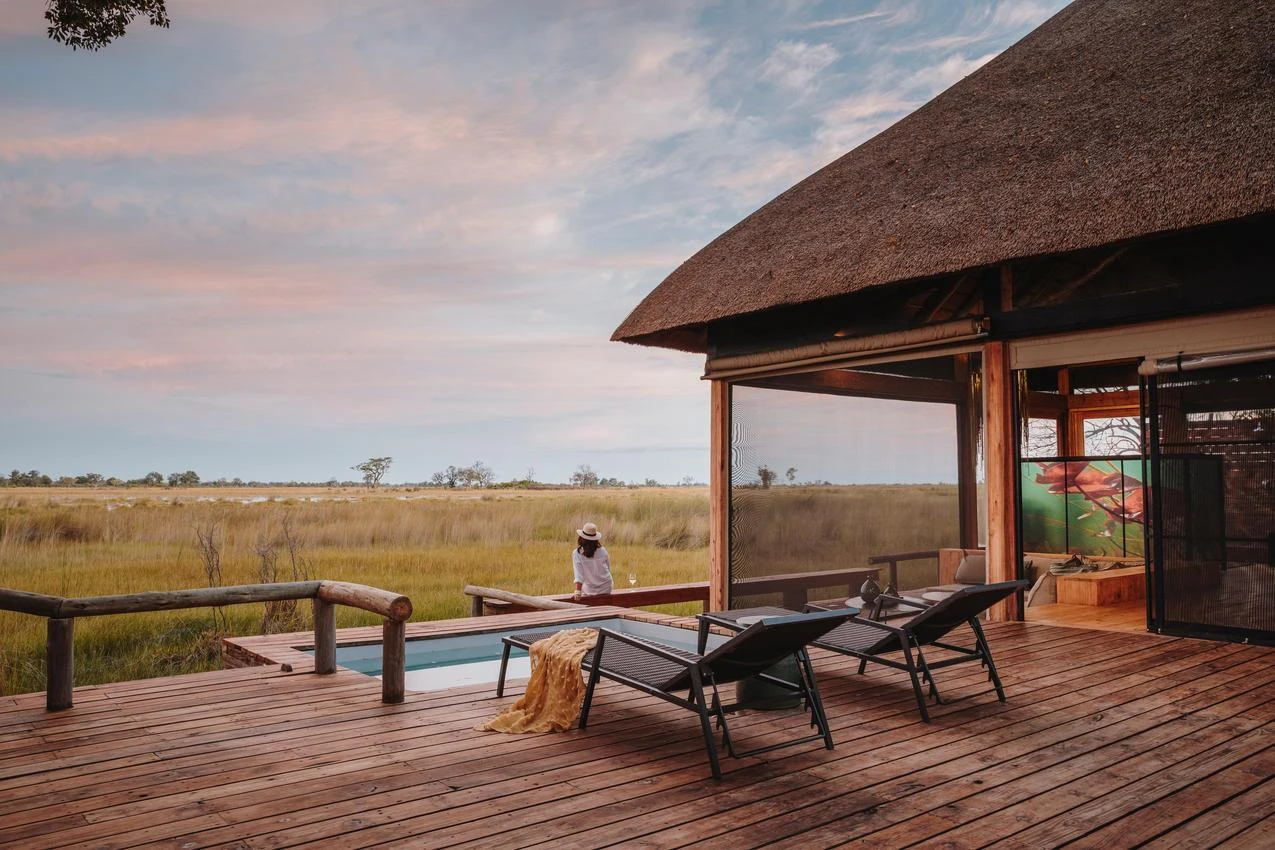 Luxury safari lodge with pool and deck overlooking African savanna. Photo safari destination.