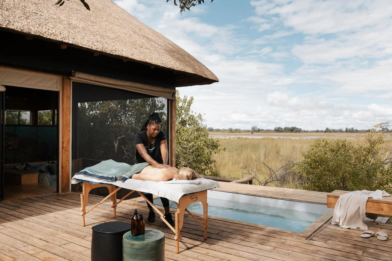 African massage on safari deck overlooking landscape. Photo safari relaxation, African safari experience.