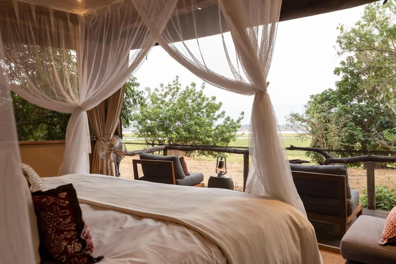 Luxury safari tent with mosquito net overlooking African landscape, perfect for a photo safari adventure.