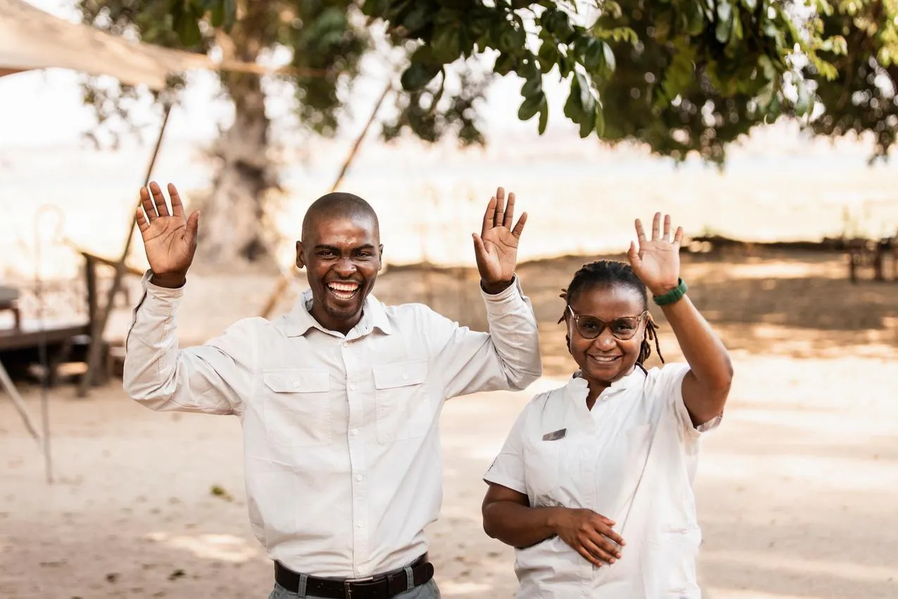 Smiling African safari guides waving. Welcoming faces on a photo safari.