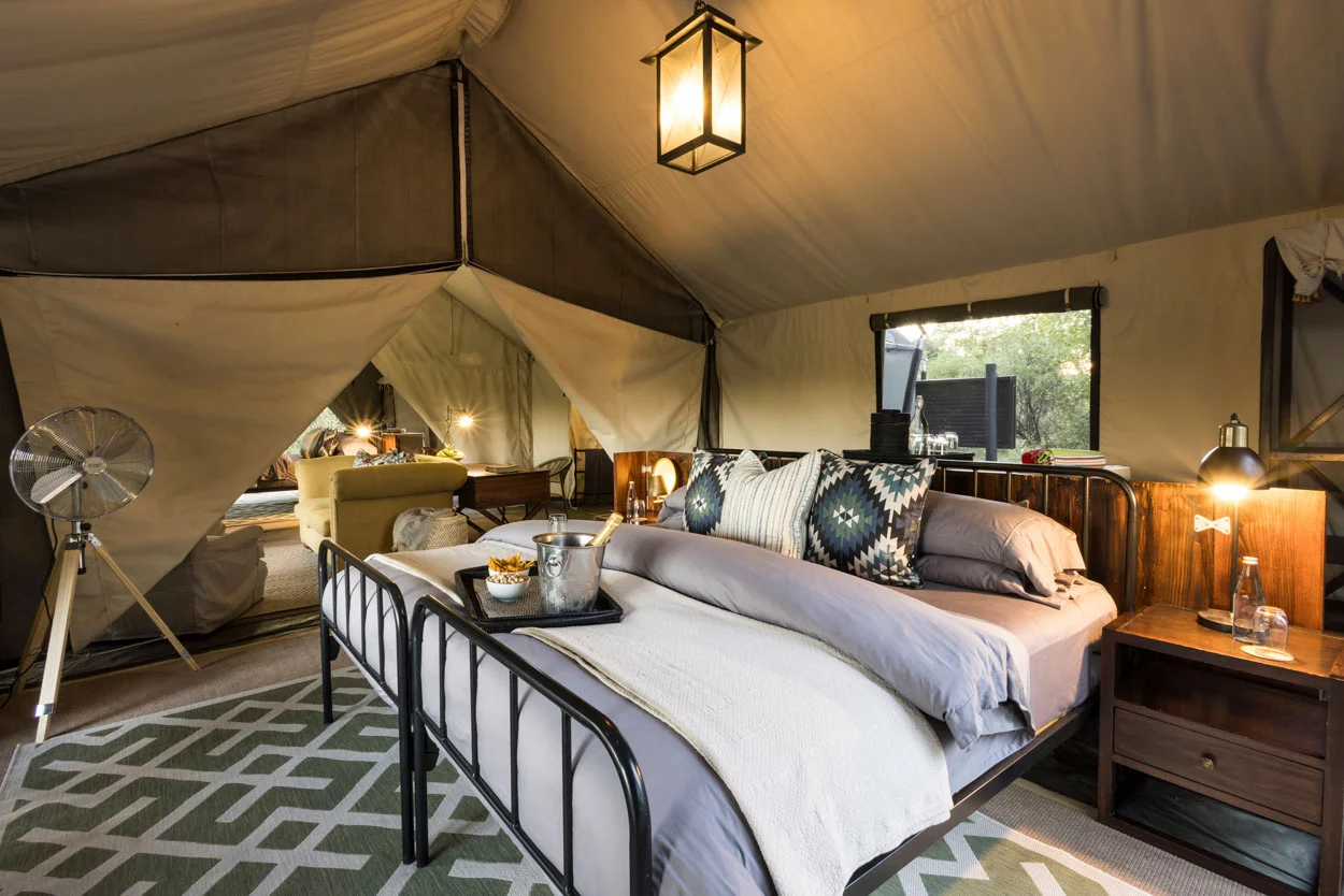 Luxury safari tent interior with bed, lounge, and decor. African safari. Photo safari.