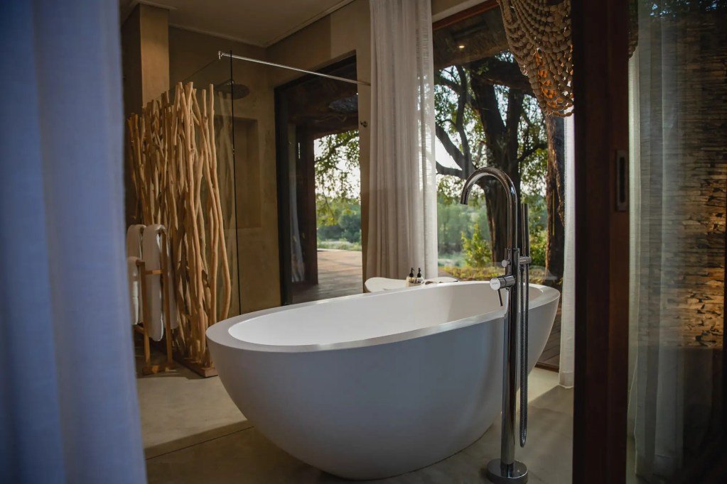 Luxury bathroom with freestanding tub overlooking nature, Uganda photo safari