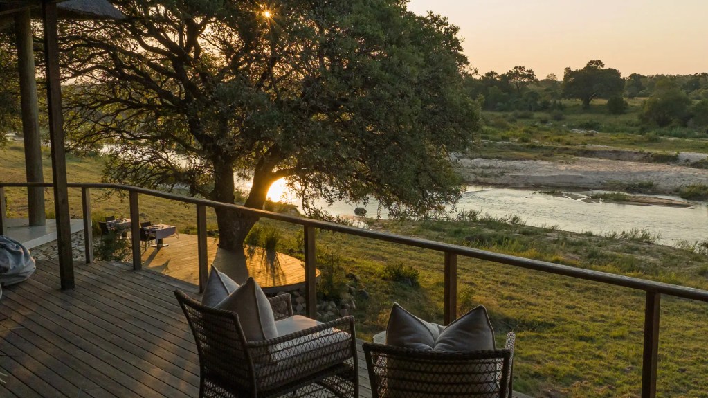 African safari lodge deck with river view at sunset, Uganda expedition photo safari