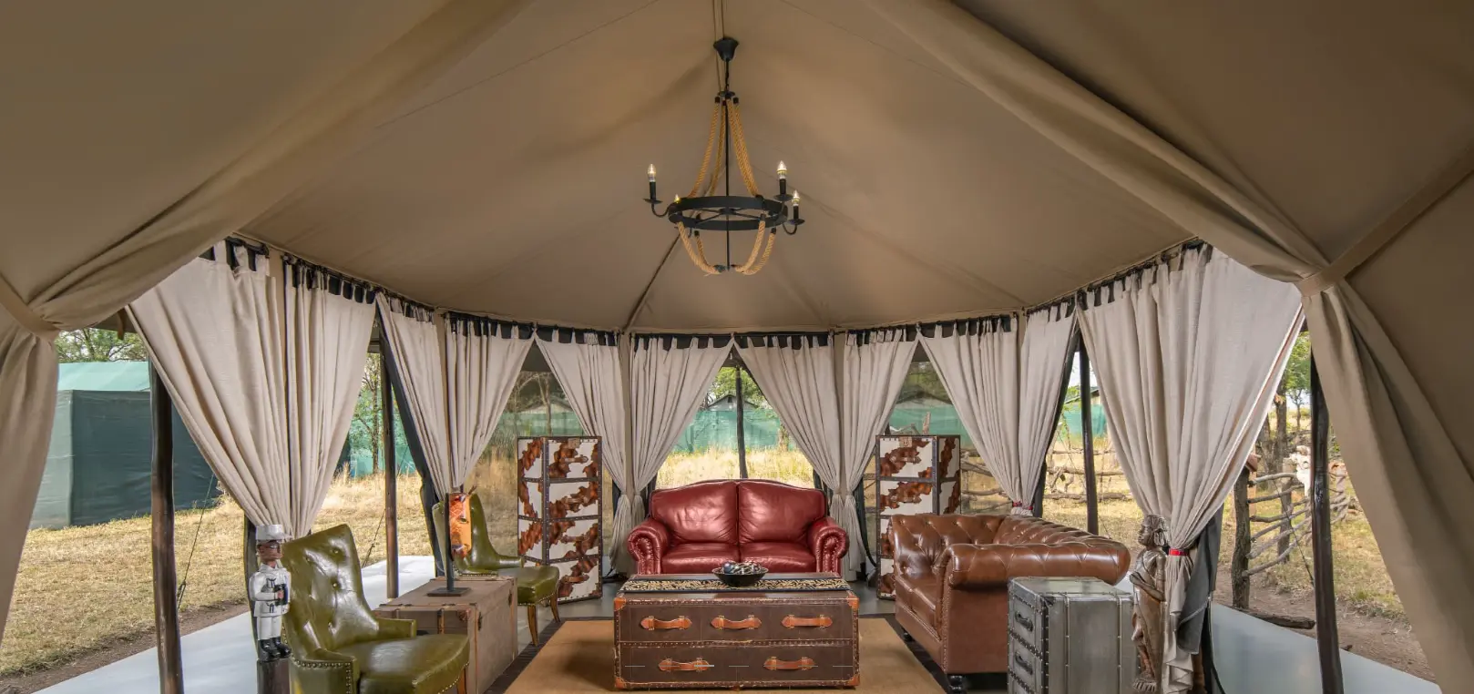 Luxury tent interior for a Serengeti safari, featuring leather seating and African decor.