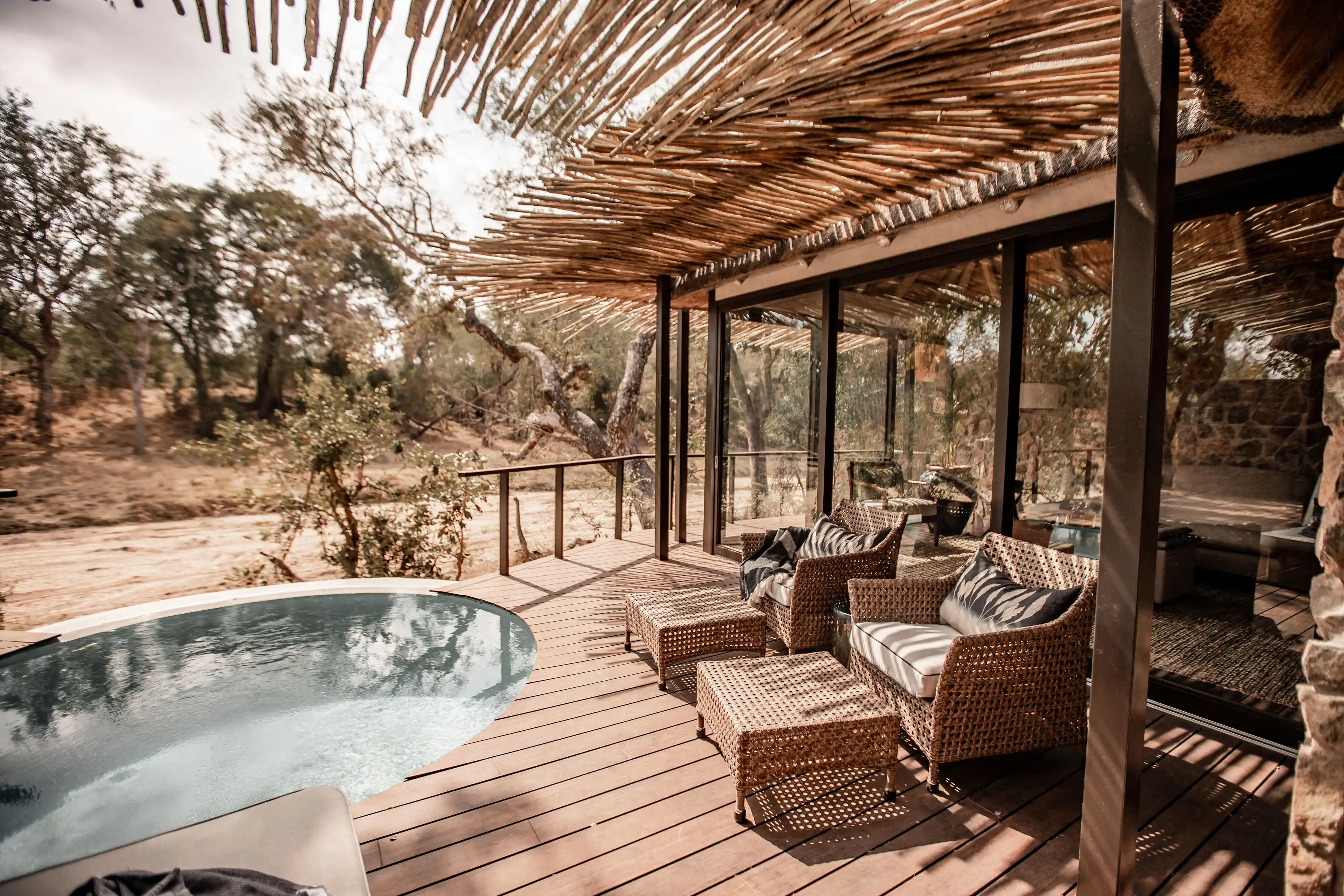 Luxury Sabi Sand lodge deck with plunge pool, outdoor seating, and savanna view – African safari photo.