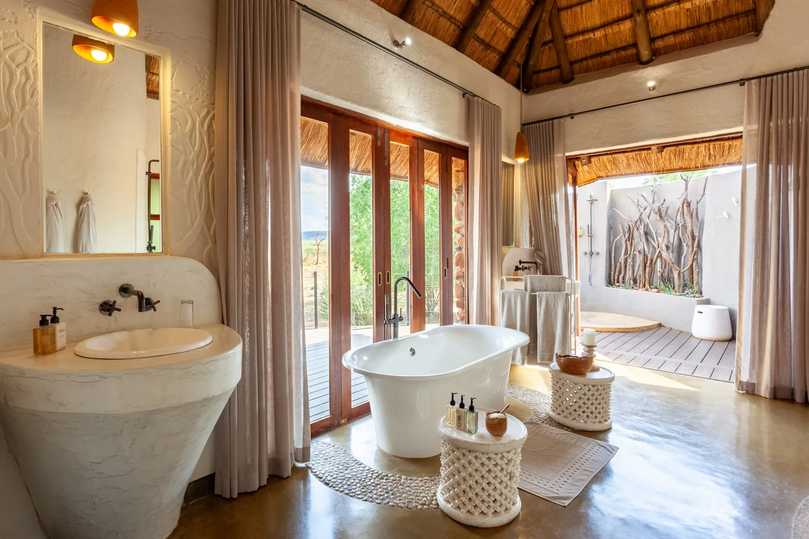Luxury bathroom with freestanding tub, safari views, African safari lodge