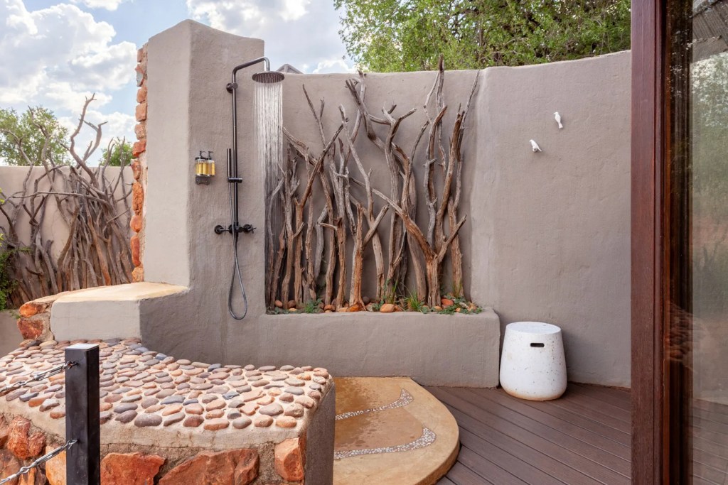 Outdoor shower with natural wood accents at a Madikwe safari lodge, perfect for a photo safari.
